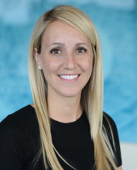 Pediatrician adivisor Dr. Kim O'hara, smiling, photographed against a soft blue textured background.