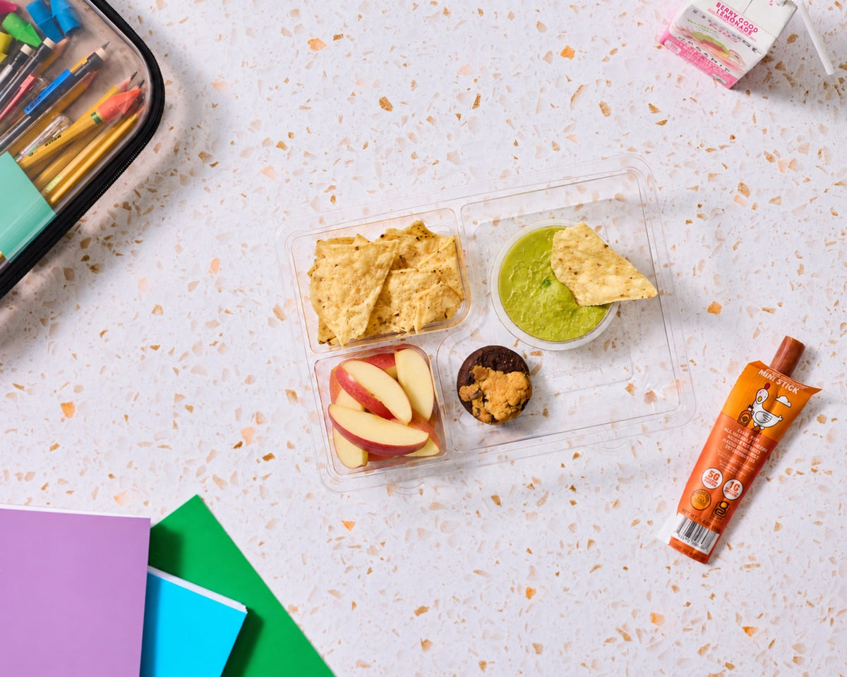 Kids' school lunch kit - like a healthy lunchable - with tortilla chips, guacamole, apple slices, brookie bite and a chicken maple jerky stick, made gluten-free, nut-free and top-9-allergen-free
