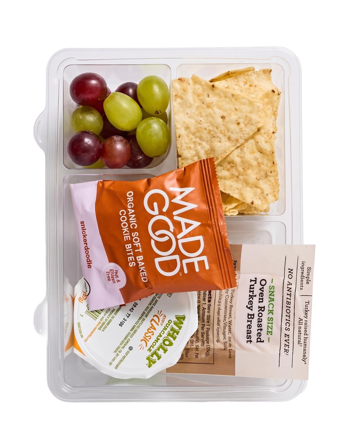 Grab-and-go  lunch bento box kit - like a healthy lunchable - with tortilla chips, guacamole, grapes, turkey slices and snickerdoodle cookies, made gluten-free, nut-free and top-9-allergen-free